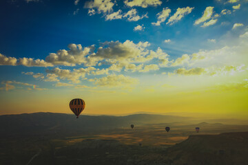 Hot air balloon drive in Cappadocia during sunrise with golden yellow background 