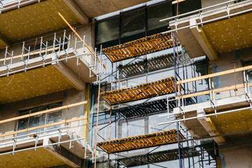 Residential houses under construction. Scaffolding on building wall on construction site