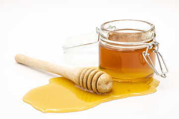 Jar of honey with honey dipper isolated on white background