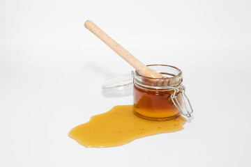 Jar of honey with honey dipper isolated on white background