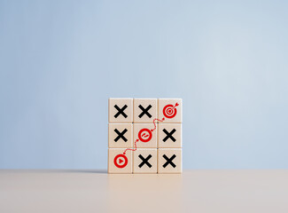 Business goal strategy planning and marketing with tic tac game and dart icons on wooden cubes. Company strategy to achieve target to be successful. Find the best direct with O and X game to target.