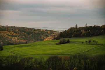 Obraz premium Scenic view of a beautiful green field on the hill