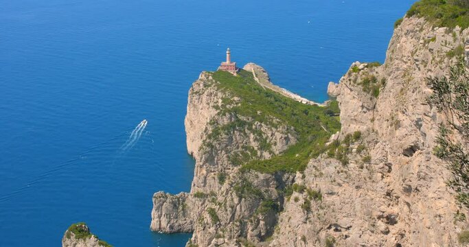 Punta Carena Lighthouse On The Clifftop Against Blue Sea In Capri, Campania, Italy. - wide, high angle