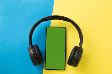 Big wireless headphones and phone. Chromakey space on the phone screen