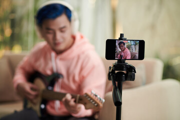 Man Recording Himself Playing Guitar