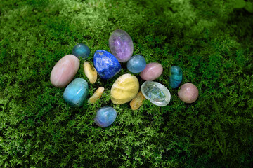 set of colorful gemstones close up on moss, natural background. minerals for esoteric Magic crystal Ritual, Witchcraft, spiritual practice. healing stone therapy for life balance, soul relax. top view