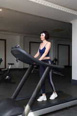Fototapeta na wymiar Girl on daily sports training in the gym by subscription.