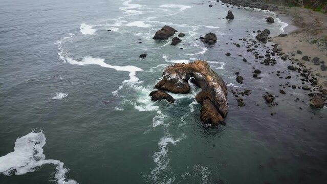 Aerial drone footage of the Arched rock in the ocean near the Highway 1, California coast