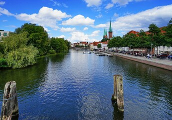Fototapeta na wymiar Scenic view of the tranquil Trave river surrounded by traditional buildings and greenery in Germany
