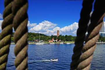 Boat sailing on the Trave river surrounded by traditional buildings on a summer day in Germany