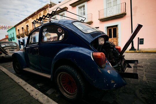 Blue classic Volkswagen Kaefer in heavy exhaust system condition in the streets of Oaxaca, Mexico