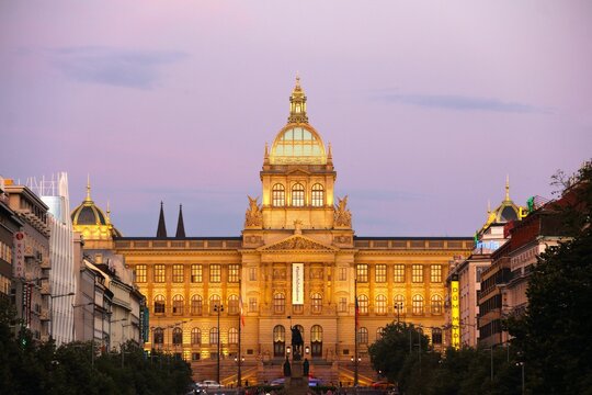 Illuminated National Museum of Prague against a pink sky during the sunset