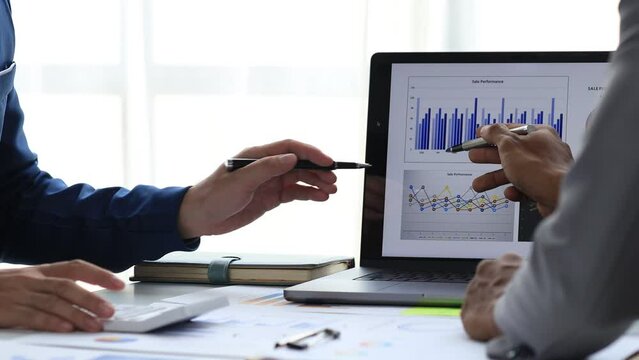 Sales are working together to summarize monthly sales to bring in a meeting with executives, female employees using smartphones to view sales data. Sales management concept.