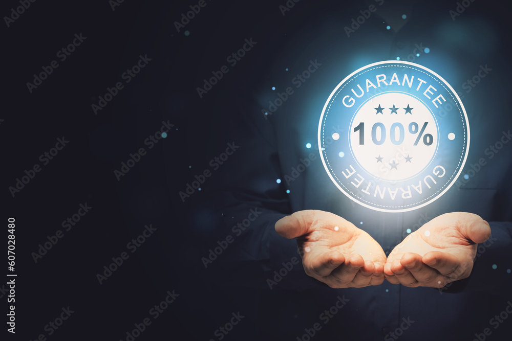 Poster close up of businessman hand holding glowing 100% guarantee stamp hologram on dark background with b