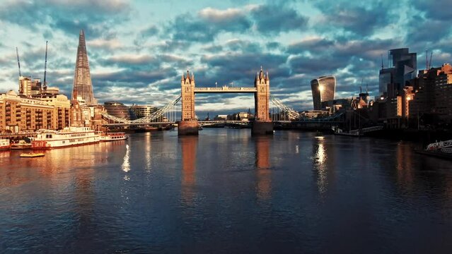 Sunrise aerial drone rising shot along river thames over Tower Bridge