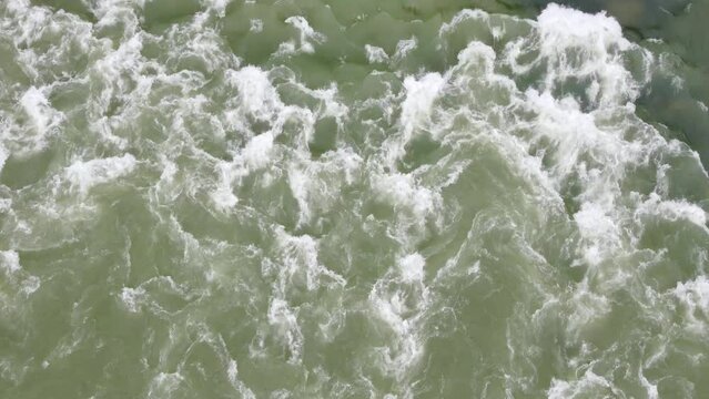 Muddy rive flowing after heavy rain. Floods in spring. River cascade in nature. 