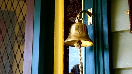 Golden doorbell in front of a blue-stained window - Powered by Adobe