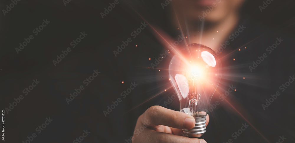 Poster hand holding the glowing lightbulb that is illuminating for creative thinking idea of problem solvin