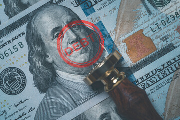 Benjamin Franklin face from USD dollar banknote with stamping debt wording for America's public debt is high and the debt ceiling needs to be raised concept.