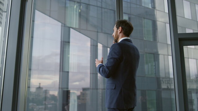 Smart businessman calling partners using smartphone in modern office close up.