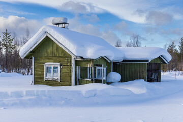 Snowed in and snow covered wooden cabin in Lapland, Finland - obrazy, fototapety, plakaty