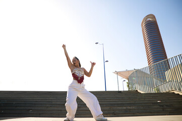 Latin woman, young and beautiful dancing modern dance in the street and makes different expressions...