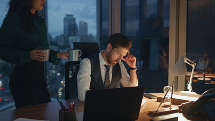 Woman bringing coffee colleague working together in office late evening.