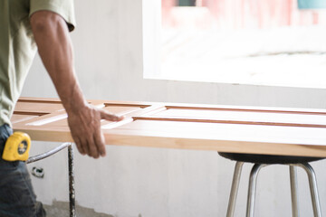 Carpenter man working with teak wooden door installation