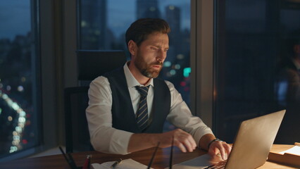 Tired entrepreneur focused typing laptop working at office late night close up.