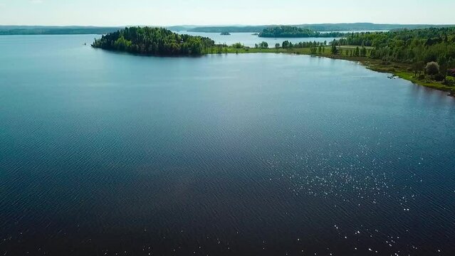 Drone footage of a scenic lake surrounded by l lush forest in Sweden