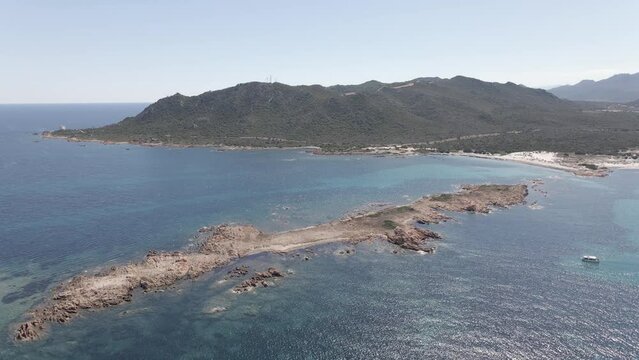 Drone shot of Isola Rossa beach with blue sea and mountain
