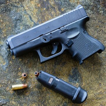 Top view of a black Glock 9mm pistol firearm handgun on a grungy surface