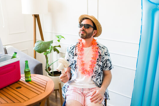 Sweaty man in his 30s feeling hot and sweating in the summer at home