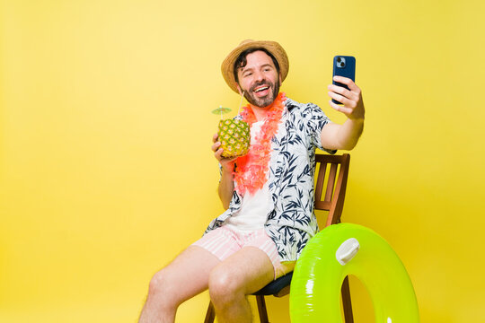 Excited mid-adult man laughing taking a selfie during summer vacations