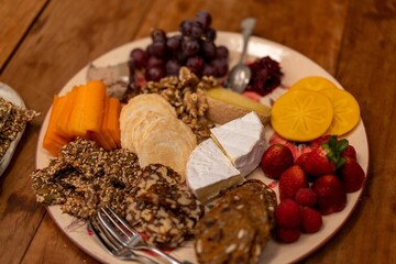 Close-up shot of a healthy breakfast plate with cheese carrots bread and strawberries
