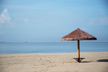 Straw shade umbrella in sea tropical region