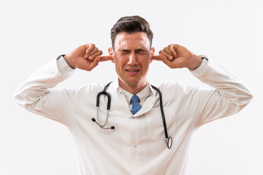 Image of overworked  doctor with hands in ears .