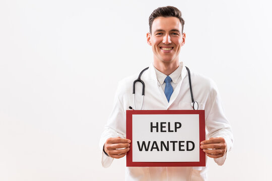 Image of doctor holding a paper with a text help wanted.