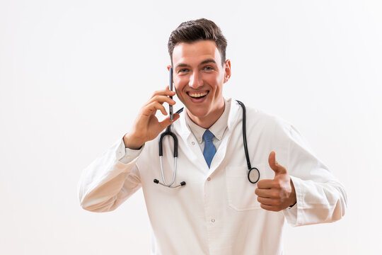 Image of happy doctor talking on the phone and showing thumb up.	
