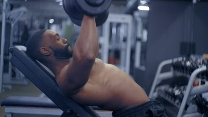 Shirtless African American performing Dumbbell Press