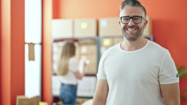 Young woman and man working on ecommerce standing at office