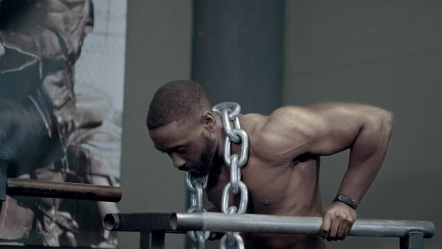 Athletic African American performing Weighted Dips