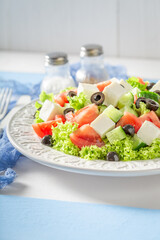 Delicious and homemade Greek salad seasoned with olive oil.