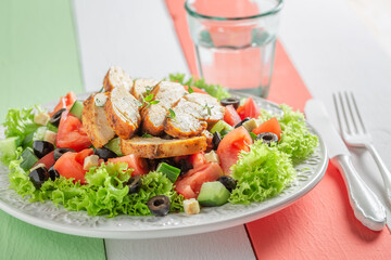 Tasty and homemade Caesar salad with chicken, lettuce and tomatoes.