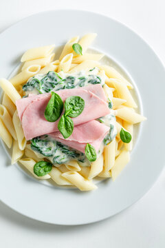 Tasty and homemade penne with ham and bechamel sauce.
