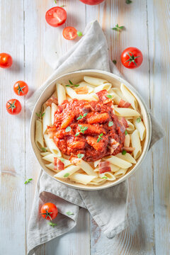Tasty and hot penne bolognese with parmesan and basil.