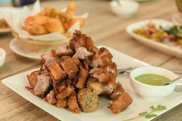 Crispy pork serve with spicy sauce on wooden table as appetizer 