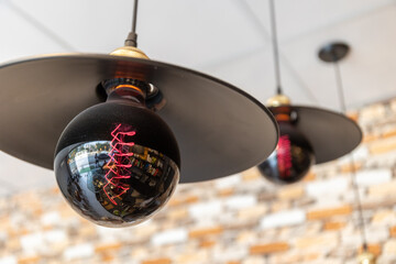 black hanging lights with red light in a hipster coffee shop