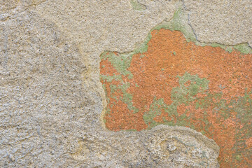 Background of old wall with collapsed plaster. Texture of shabby weathered building surface. Destroyed wall with fallen plaster. Copy space. Selective focus.