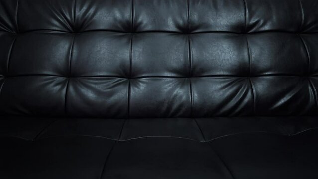 Slider shot of Texture of beautiful black leather sofa.
